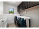 Functional laundry room with modern appliances, cabinet storage, and a convenient folding area for easy chores at 4611 Grand Preserve Pl, Palm Harbor, FL 34684