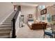 Bright living room with tall ceilings, staircase, and view into kitchen with dark cabinets and center island at 4611 Grand Preserve Pl, Palm Harbor, FL 34684