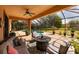 Enjoy outdoor living on this screened-in patio with cozy seating, a firepit, and views of the private backyard at 4611 Grand Preserve Pl, Palm Harbor, FL 34684