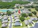 Aerial view of a suburban home near a pond, featuring mature trees and manicured lawns in a neighborhood at 4690 Coachford Dr, Wesley Chapel, FL 33543