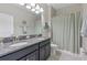 Bathroom featuring double sinks with granite countertop and shower with modern curtain at 4690 Coachford Dr, Wesley Chapel, FL 33543
