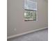 Bright bedroom featuring a window with blinds and neutral carpeting at 4690 Coachford Dr, Wesley Chapel, FL 33543