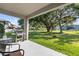 Covered patio featuring an outdoor dining set and grill, with a view of the backyard at 4690 Coachford Dr, Wesley Chapel, FL 33543