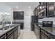 Well-lit kitchen boasts sleek, dark cabinetry, granite countertops and stainless steel appliances at 4690 Coachford Dr, Wesley Chapel, FL 33543