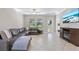 Living room featuring tiled floors, a leather couch, ceiling fan, and outdoor views at 4690 Coachford Dr, Wesley Chapel, FL 33543
