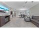 Bright living space featuring tile floors and large windows, adjoining the dining area and kitchen at 4690 Coachford Dr, Wesley Chapel, FL 33543