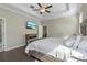 Comfortable main bedroom with en-suite bathroom, tray ceilings, and hardwood flooring at 4690 Coachford Dr, Wesley Chapel, FL 33543
