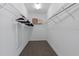Bright walk-in closet with built-in shelving and sleek wood-look flooring at 4690 Coachford Dr, Wesley Chapel, FL 33543