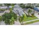 Aerial view of home surrounded by mature trees and lush landscaping, with an oversized driveway at 4915 Augusta Ave, Oldsmar, FL 34677