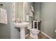 Charming powder room featuring a pedestal sink, decorative mirror, and elegant fixtures at 4915 Augusta Ave, Oldsmar, FL 34677