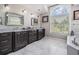 Luxurious primary bathroom with double vanity, large mirror, tub and natural light at 4915 Augusta Ave, Oldsmar, FL 34677