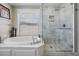 Bright primary bath with soaking tub and marble tiled walk-in shower at 4915 Augusta Ave, Oldsmar, FL 34677