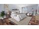 A bright bedroom with light blue walls, wooden floors, neutral rug, and comfortable furniture at 4915 Augusta Ave, Oldsmar, FL 34677