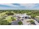 Aerial shot of the clubhouse, parking lot and golf course with lush trees and a blue sky at 4915 Augusta Ave, Oldsmar, FL 34677