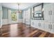 Traditional dining room showcasing hardwood floors, wainscoting, a large mirror, and ample natural light at 4915 Augusta Ave, Oldsmar, FL 34677