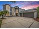 Elegant two-story home with an arched entryway, three-car garage, and a spacious concrete driveway at 4915 Augusta Ave, Oldsmar, FL 34677