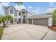 Two-story home featuring a stucco exterior, three-car garage, and ample parking space in driveway at 4915 Augusta Ave, Oldsmar, FL 34677