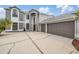 Two-story home featuring a stucco exterior, three-car garage, and ample parking space in driveway at 4915 Augusta Ave, Oldsmar, FL 34677