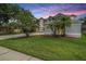 Beautiful two-story home featuring an oversized lot with lush green lawn and tropical landscaping at 4915 Augusta Ave, Oldsmar, FL 34677