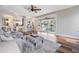 Bright living room with hardwood floors, ceiling fan, and sliding glass doors leading to a pool at 4915 Augusta Ave, Oldsmar, FL 34677