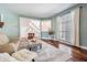 Cozy living room with a neutral color scheme, hardwood floors, and a view of the staircase and front window at 4915 Augusta Ave, Oldsmar, FL 34677