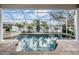 Screened-in pool and hot tub area with tiled accents, columnar supports, and tropical landscaping at 4915 Augusta Ave, Oldsmar, FL 34677