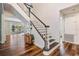 Elegant staircase with wooden steps, white risers, and decorative woodwork next to a sunny living area at 4915 Augusta Ave, Oldsmar, FL 34677