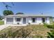 Charming single-story home with a freshly painted white exterior and well-manicured front yard at 5341 Tangerine Dr, Zephyrhills, FL 33542