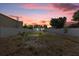 Spacious fenced backyard with some trees, offering ample room for outdoor activities and relaxation at dusk at 5405 59Th N St, St Petersburg, FL 33709