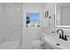 Elegant bathroom with marble wall, white fixtures and decor, and natural light at 5405 59Th N St, St Petersburg, FL 33709
