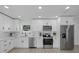 Modern kitchen with white cabinets, stainless steel appliances, and quartz countertops at 5405 59Th N St, St Petersburg, FL 33709
