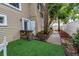Backyard showing an area with artificial turf, landscaping, and a pathway leading to the main outdoor areas at 546 26Th N Ave, St Petersburg, FL 33704