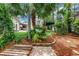 Lush backyard featuring a stone pathway, garden beds, mature trees, and a view of the home at 546 26Th N Ave, St Petersburg, FL 33704