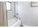 Bright bathroom featuring a white tub with shower, neutral tile, and a window for natural light at 546 26Th N Ave, St Petersburg, FL 33704