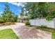 Well-manicured lawn, a charming home with a covered porch, and a brick driveway behind a white fence at 546 26Th N Ave, St Petersburg, FL 33704