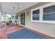 Spacious covered porch with outdoor seating, brick flooring, and views of the well-maintained yard and front door at 546 26Th N Ave, St Petersburg, FL 33704