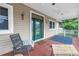Cozy covered porch with comfortable seating, brick flooring, and a stylish front door, perfect for relaxing outdoors at 546 26Th N Ave, St Petersburg, FL 33704