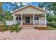 Inviting home with a covered porch, brick steps, and a stylish front door, surrounded by lush landscaping at 546 26Th N Ave, St Petersburg, FL 33704