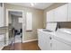 Convenient laundry room with washer, dryer, storage cabinets, and tiled floor leading to a storage area at 546 26Th N Ave, St Petersburg, FL 33704