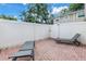 Private patio with brick flooring, white fence and two sun loungers at 546 26Th N Ave, St Petersburg, FL 33704