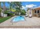 Sparkling pool with a patio, lush landscaping, lounge chairs, and umbrella for outdoor enjoyment at 546 26Th N Ave, St Petersburg, FL 33704