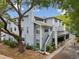 Two-story light blue house with chimney, outdoor stairwell, and front garden at 5729 Calais N Blvd # 6, St Petersburg, FL 33714
