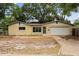 Single-story home featuring a beige exterior, simple landscaping, and a two-car garage at 701 59Th Ne Ave, St Petersburg, FL 33703