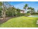 Expansive backyard featuring a well-manicured lawn, lush landscaping, and a sparkling in-ground pool at 7032 Pelican Island Dr, Tampa, FL 33634