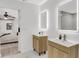 Bright bathroom featuring modern vanities with an open doorway to the bedroom at 7032 Pelican Island Dr, Tampa, FL 33634