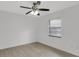 Well-lit bedroom with light wood floors, a ceiling fan, and a window for natural light at 7032 Pelican Island Dr, Tampa, FL 33634