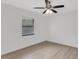 Bright bedroom featuring a ceiling fan, light wood floors, and a window for ample natural light at 7032 Pelican Island Dr, Tampa, FL 33634