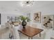 Elegant dining room with modern lighting, wood table, and views to the living room at 7032 Pelican Island Dr, Tampa, FL 33634
