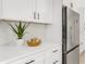Close up of kitchen features stainless steel refrigerator, quartz countertop, white cabinetry, and stylish backsplash at 7032 Pelican Island Dr, Tampa, FL 33634