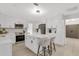 Modern white kitchen with stainless steel appliances and an island with seating at 7032 Pelican Island Dr, Tampa, FL 33634